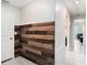 Hallway features a wooden accent wall and neutral tile flooring that leads to other rooms in the home at 146 Rain Berry Ave, Ruskin, FL 33570