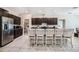 Modern kitchen with dark cabinets, granite countertops, stainless steel appliances, and a center island with seating at 146 Rain Berry Ave, Ruskin, FL 33570