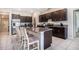 Modern kitchen with dark cabinetry, granite countertops, stainless steel appliances, and a center island with barstool seating at 146 Rain Berry Ave, Ruskin, FL 33570