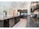 Kitchen with dark cabinets, granite countertops, stainless steel appliances, and tile flooring at 146 Rain Berry Ave, Ruskin, FL 33570