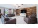 Bright living room boasts tile flooring, wood accent wall, and comfortable leather seating at 146 Rain Berry Ave, Ruskin, FL 33570