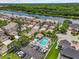 Aerial shot showcasing a community pool with lounge area, set amongst well-maintained homes and lush landscaping near a waterway at 1622 Lago Vista Blvd, Palm Harbor, FL 34685