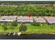 Aerial view of condo featuring a screened-in patio with a grassy lawn flowing to a canal perfect for boating at 1622 Lago Vista Blvd, Palm Harbor, FL 34685