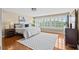 Bedroom with hardwood flooring, large windows, and a comfortable bed offers a bright and open space at 1622 Lago Vista Blvd, Palm Harbor, FL 34685