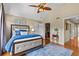 Bedroom with hardwood flooring, ceiling fan, and ensuite bathroom features large windows for natural light and backyard views at 1622 Lago Vista Blvd, Palm Harbor, FL 34685