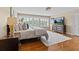 Bedroom with hardwood flooring, large windows, and a comfortable bed offers a peaceful and relaxing space at 1622 Lago Vista Blvd, Palm Harbor, FL 34685
