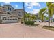 Beautiful multi-story townhome with a brick paver driveway and lush landscaping showcasing its curb appeal at 1622 Lago Vista Blvd, Palm Harbor, FL 34685