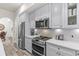 Contemporary kitchen showcases stainless steel appliances, quartz countertops, and stylish gray cabinetry at 1622 Lago Vista Blvd, Palm Harbor, FL 34685