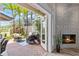 Inviting outdoor patio with brick pavers, comfortable seating, fireplace, and tropical landscaping at 1622 Lago Vista Blvd, Palm Harbor, FL 34685