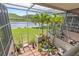 A private screened patio with outdoor seating and lush tropical landscaping, perfect for serene relaxation at 1622 Lago Vista Blvd, Palm Harbor, FL 34685
