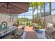 Charming outdoor patio with shaded dining and lounge areas overlooking beautiful pond with lush landscaping at 1622 Lago Vista Blvd, Palm Harbor, FL 34685