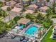 Close-up aerial of a community pool area, highlighting lounge chairs, landscaping, and nearby residential buildings at 1622 Lago Vista Blvd, Palm Harbor, FL 34685