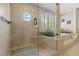 Elegant glass shower with a unique circular window, built in seating, and luxurious finishes for a spa-like experience at 1622 Lago Vista Blvd, Palm Harbor, FL 34685