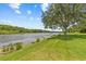 Beautiful waterfront view with lush green lawn, boat dock and mature tree creating a tranquil setting at 1622 Lago Vista Blvd, Palm Harbor, FL 34685