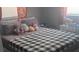 Comfortable bedroom with a soft gray color scheme and a cozy black and white checkered blanket at 1631 St Mary Dr, Dunedin, FL 34698