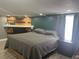 Relaxing bedroom featuring a decorative wood panel accent wall and natural light at 1631 St Mary Dr, Dunedin, FL 34698