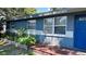 Charming home featuring a well-manicured front yard and inviting blue exterior with a quaint front porch at 1631 St Mary Dr, Dunedin, FL 34698