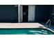Poolside view of the backyard; showcases the French doors leading to the interior at 1631 St Mary Dr, Dunedin, FL 34698