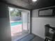 View of the pool area from the interior; features brick pavers, a sleek lounge area, and a decorative ceiling at 1631 St Mary Dr, Dunedin, FL 34698