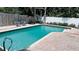 Backyard pool area features a blue pool, brick paver deck, lounge chairs, and manicured landscaping at 1631 St Mary Dr, Dunedin, FL 34698