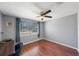 Bright bedroom featuring a ceiling fan, wood floors, and a large window at 1706 Sloop Pl, Brandon, FL 33511
