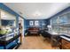 Well-lit home office with custom desk, piano, and blue accent wall perfect for working from home at 1706 Sloop Pl, Brandon, FL 33511