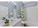 Bathroom featuring a shower/tub combo with white tile, a blue wall, and an undermount sink at 18017 Palm Breeze Dr, Tampa, FL 33647