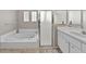 Bathroom featuring a jetted tub, shower, and a white vanity with solid surface countertop at 18017 Palm Breeze Dr, Tampa, FL 33647