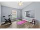 Bonus room with wood-look floors, a ceiling fan, exercise equipment, and a bright window at 18017 Palm Breeze Dr, Tampa, FL 33647