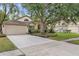 Charming single-story home with a large driveway, mature landscaping, and a welcoming facade at 18017 Palm Breeze Dr, Tampa, FL 33647