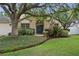 Beautiful home exterior featuring lush landscaping, mature trees, and a welcoming front entrance at 18017 Palm Breeze Dr, Tampa, FL 33647