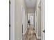 Hallway featuring wood-look floors and neutral walls connecting various rooms at 18017 Palm Breeze Dr, Tampa, FL 33647