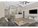 Spacious living room with vaulted ceilings, gray wood-look flooring, and a modern ceiling fan at 18017 Palm Breeze Dr, Tampa, FL 33647