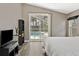 Bedroom with wood floors and views of the screened pool area from the glass sliding door at 18017 Palm Breeze Dr, Tampa, FL 33647