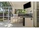 Outdoor kitchen with a BBQ grill, sink, and a mini-refrigerator at 18017 Palm Breeze Dr, Tampa, FL 33647