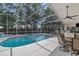 Inviting screened-in pool area featuring a jacuzzi, outdoor kitchen and dining area at 18017 Palm Breeze Dr, Tampa, FL 33647