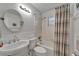 Bathroom features a classic white sink, toilet, and shower/tub combination with striped curtain at 1813 Allegheny Dr, Sun City Center, FL 33573