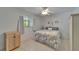 Cozy bedroom featuring tile floors, a ceiling fan, and a comfortable bed with floral patterned comforter at 1813 Allegheny Dr, Sun City Center, FL 33573