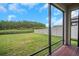Screened-in patio with serene backyard view overlooking the pond and lush landscaping at 19238 Old Spanish Rd, Tampa, FL 33647