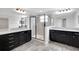 Elegant bathroom with dual vanities, quartz countertops, dark cabinets, and a glass-enclosed shower at 19238 Old Spanish Rd, Tampa, FL 33647