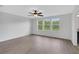 Bright bedroom with hardwood floors and three large windows showcasing a green view at 19238 Old Spanish Rd, Tampa, FL 33647
