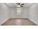 Bedroom with hardwood floors, ceiling fan, and window with shutter at 19238 Old Spanish Rd, Tampa, FL 33647