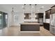 Modern kitchen featuring a granite island, stainless steel appliances, dark cabinets and wood laminate flooring at 19238 Old Spanish Rd, Tampa, FL 33647