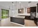 Modern kitchen with dark wood cabinets, stainless steel appliances, and a granite island with pendant lighting at 19238 Old Spanish Rd, Tampa, FL 33647