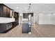Modern kitchen featuring a granite island, stainless steel appliances, dark cabinets and wood laminate flooring at 19238 Old Spanish Rd, Tampa, FL 33647
