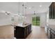 Modern kitchen featuring a granite island, stainless steel appliances, dark cabinets and wood laminate flooring at 19238 Old Spanish Rd, Tampa, FL 33647