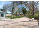 Expansive backyard featuring a concrete patio, lush lawn, and mature trees creates a private outdoor oasis at 2010 Bayview Pl, Indian Rocks Beach, FL 33785