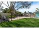 Spacious backyard with a large concrete area, lush grass, and mature trees provides a serene retreat at 2010 Bayview Pl, Indian Rocks Beach, FL 33785