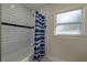 Bright bathroom with a subway tile shower, contrasting black stripe, and a window with a breeze at 2010 Bayview Pl, Indian Rocks Beach, FL 33785