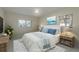 Staged bedroom features a ceiling fan, two windows and a bed with white linens and light blue decorative pillows at 2010 Bayview Pl, Indian Rocks Beach, FL 33785